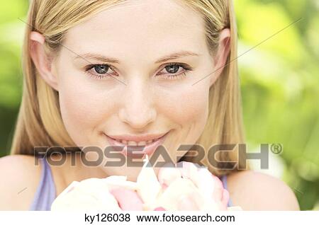Portrait of a young blond woman smiling, holding petals, outdoors View Large Photo Image Stock Photo - Portrait of a young blond woman smiling, holding petals, outdoors. Fotosearch