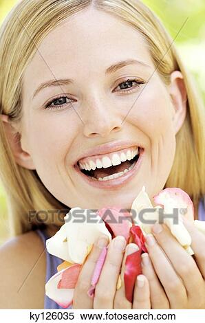 Portrait of a young blond woman smiling, holding petals, outdoors View Large Photo Image Stock Photography - Portrait of a young blond woman smiling, holding petals, outdoors. Fotosearch