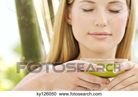 Portrait of a young woman, eyes shut, holding a green tea cup, outdoors View Large Photo Image Stock Image - Portrait of a young woman, eyes shut, holding a green tea cup, outdoors. Fotosearch
