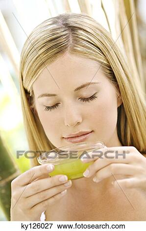 Stock Photo - Portrait of a young woman holding a green tea cup, outdoors. Fotosearch