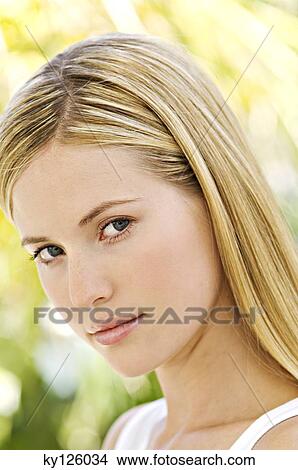 Portrait of a young woman looking at the camera, outdoors View Large Photo Image Picture - Portrait of a young woman looking at the camera, outdoors. Fotosearch