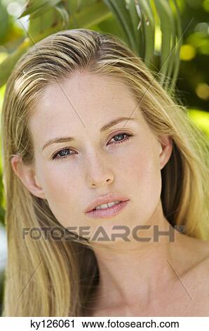 Portrait of a young woman looking at the camera, outdoors View Large Photo Image Stock Image - Portrait of a young woman looking at the camera, outdoors. Fotosearch
