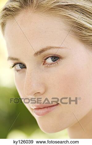 Portrait of a young woman looking at the camera, outdoors View Large Photo Image Stock Photo - Portrait of a young woman looking at the camera, outdoors. Fotosearch