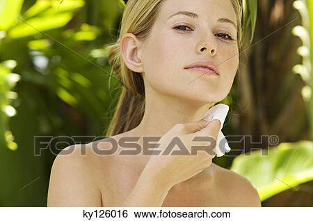 Portrait of a young woman using a cleansing cotton on her neck, outdoors View Large Photo Image Stock Photograph - Portrait of a young woman using a cleansing cotton on her neck, outdoors. Fotosearch
