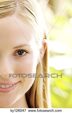 Portrait of half of a young woman's face, smiling, looking at the camera, close-up, outdoors View Large Photo Image Stock Photo - Portrait of half of a young woman's face, smiling, looking at the camera, close-up, outdoors. Fotosearch