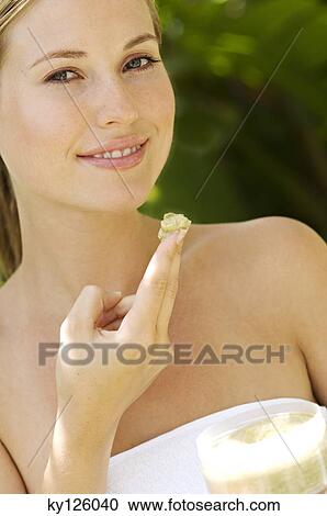 Young woman applying face scrub cream on her face, outdoors View Large Photo Image Stock Image - Young woman applying face scrub cream on her face, outdoors. Fotosearch