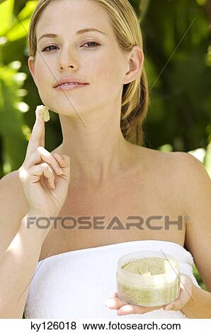 Young woman applying face scrub cream on her face, outdoors View Large Photo Image Stock Photo - Young woman applying face scrub cream on her face, outdoors. Fotosearch