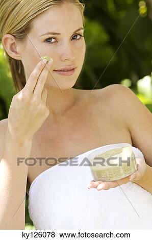Young woman applying face scrub cream on her face, outdoors View Large Photo Image Stock Photo - Young woman applying face scrub cream on her face, outdoors. Fotosearch