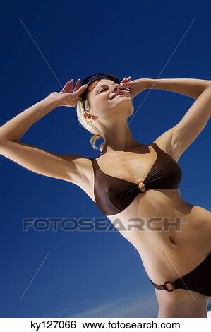 Young smiling woman in bikini on the beach, sunglasses View Large Photo Image Stock Photograph - Young smiling woman in bikini on the beach, sunglasses. Fotosearch