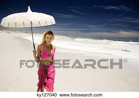 Young woman in bikini and pareo with parasol on the beach View Large Photo Image Stock Image - Young woman in bikini and pareo with parasol on the beach. Fotosearch