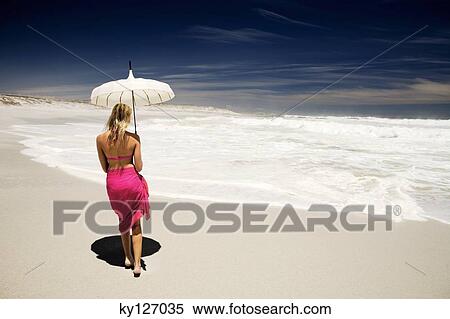 Young woman in bikini and pareo with parasol on the beach, rear view View Large Photo Image Stock Photography - Young woman in bikini and pareo with parasol on the beach, rear view. Fotosearch