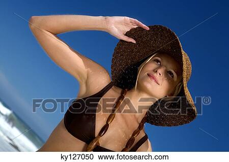 Young woman in bikini on the beach, hat and necklace View Large Photo Image Stock Image - Young woman in bikini on the beach, hat and necklace. Fotosearch