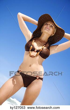 Young woman in bikini on the beach, hat and necklace View Large Photo Image Stock Image - Young woman in bikini on the beach, hat and necklace. Fotosearch
