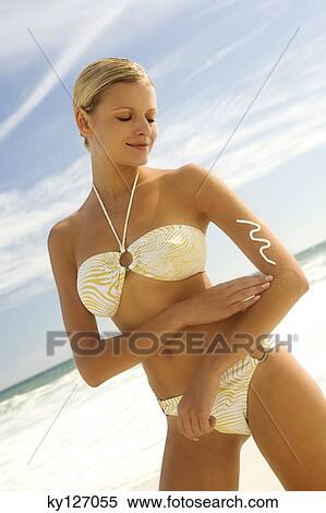 Young woman in bikini on the beach applying sun cream View Large Photo Image Stock Photography - Young woman in bikini on the beach applying sun cream. Fotosearch