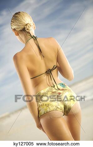Young woman in bikini standing on beach, rear view View Large Photo Image Stock Photography - Young woman in bikini standing on beach, rear view. Fotosearch