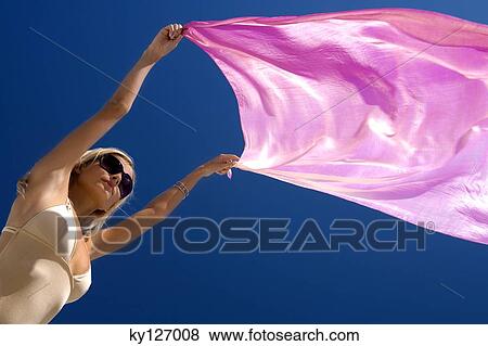 Young woman in swimming costume holding pink pareo in wind View Large Photo Image Stock Photo - Young woman in swimming costume holding pink pareo in wind. Fotosearch