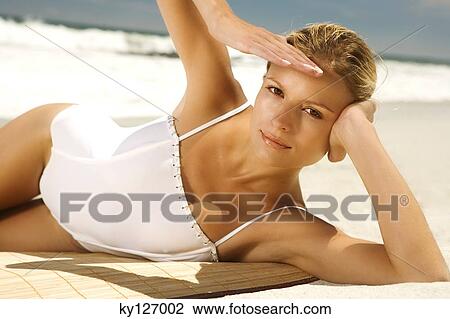Young woman in swimming costume lying on the beach View Large Photo Image Stock Image - Young woman in swimming costume lying on the beach. Fotosearch