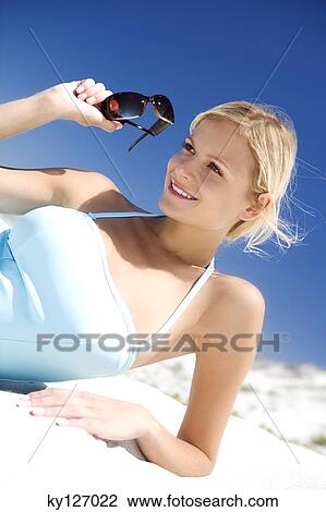 Young woman in swimming costume lying on the beach View Large Photo Image Stock Image - Young woman in swimming costume lying on the beach. Fotosearch