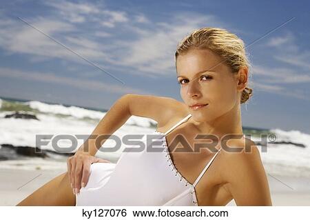 Young woman in swimming costume lying on the beach View Large Photo Image Stock Photograph - Young woman in swimming costume lying on the beach. Fotosearch