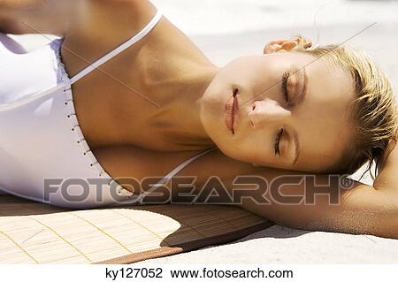 Young woman in swimming costume, sleeping on the beach View Large Photo Image Stock Image - Young woman in swimming costume, sleeping on the beach. Fotosearch