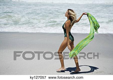 Young woman in swimming costume, walking on the beach View Large Photo Image Stock Photo - Young woman in swimming costume, walking on the beach. Fotosearch