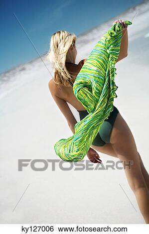Young woman in swimming costume, walking on the beach, rear view View Large Photo Image Stock Photograph - Young woman in swimming costume, walking on the beach, rear view. Fotosearch