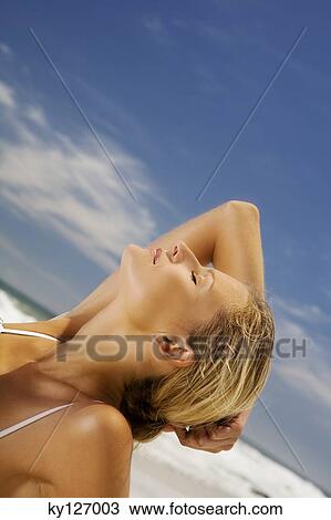 Young woman lying on beach, head back View Large Photo Image Stock Image - Young woman lying on beach, head back. Fotosearch