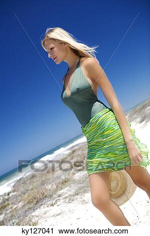Young woman walking on the beach View Large Photo Image Stock Image - Young woman walking on the beach. Fotosearch