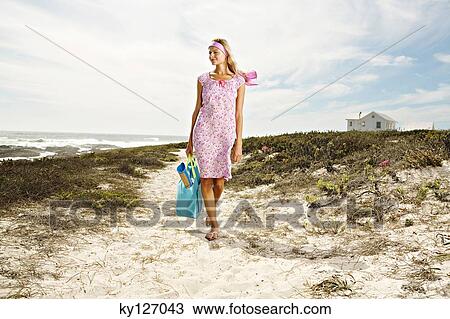 Young woman walking on the beach View Large Photo Image Stock Image - Young woman walking on the beach. Fotosearch