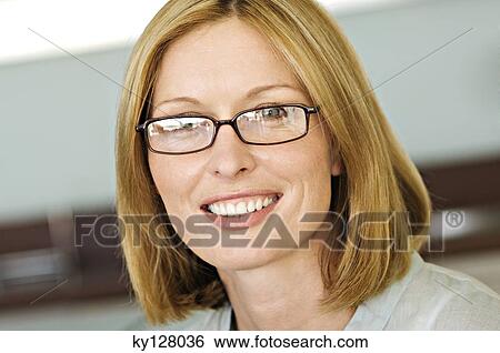 Stock Photograph - Portrait of a smiling woman with eye glasses. Fotosearch