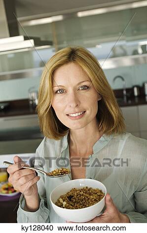 Portrait of a woman eating cereal View Large Photo Image Stock Image - Portrait of a woman eating cereal. Fotosearch
