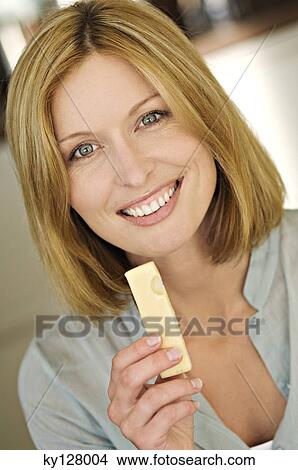 Picture - Portrait of a woman eating cheese. Fotosearch