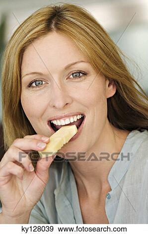 Portrait of a woman eating cheese View Large Photo Image Stock Photo - Portrait of a woman eating cheese. Fotosearch