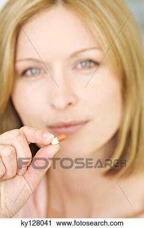 Portrait of a woman holding capsule View Large Photo Image Stock Image - Portrait of a woman holding capsule. Fotosearch