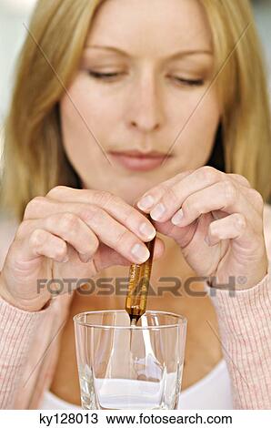 Woman breaking ampoule in a glass View Large Photo Image Stock Image - Woman breaking ampoule in a glass. Fotosearch