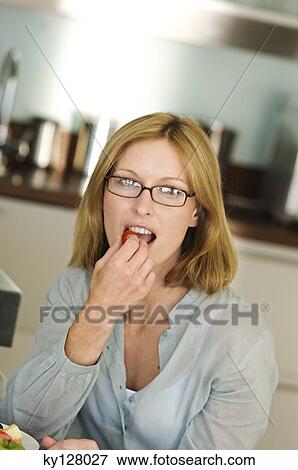 Stock Photo - Woman eating cherry-tomato. Fotosearch
