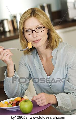 Woman eating fruit salad View Large Photo Image Stock Photo - Woman eating fruit salad. Fotosearch