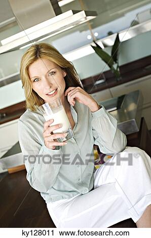 Woman holding glass of milk View Large Photo Image Stock Image - Woman holding glass of milk. Fotosearch