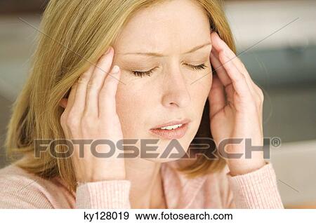 Stock Photo - Woman with hands on temples, eyes closed. Fotosearch