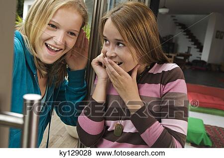 2 smiling teenage girls using mobile phone View Large Photo Image Stock Photo - 2 smiling teenage girls using mobile phone. Fotosearch