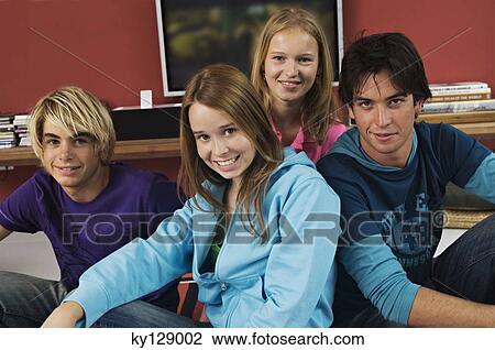 Stock Image - 2 teenage boys and 2 teenage girls smiling for camera. Fotosearch