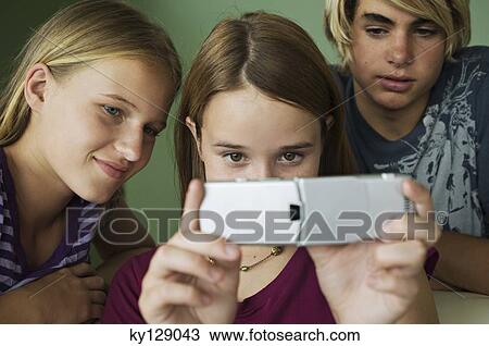 2 teenage girls and boy using camera phone View Large Photo Image Stock Image - 2 teenage girls and boy using camera phone. Fotosearch