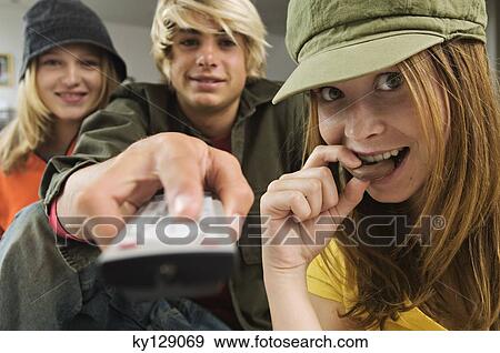 2 teenage girls and teenage boy using remote control View Large Photo Image Stock Photo - 2 teenage girls and teenage boy using remote control. Fotosearch