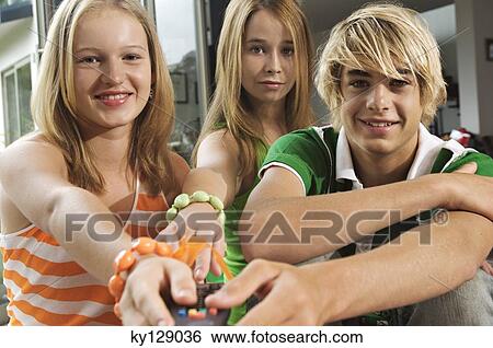 2 teenage girls and teenage boy using remote control View Large Photo Image Stock Photograph - 2 teenage girls and teenage boy using remote control. Fotosearch