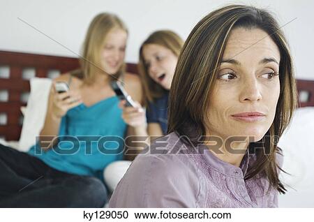 2 teenage girls sitting on bed, using mobile phones, thinking woman in foreground View Large Photo Image Stock Image - 2 teenage girls sitting on bed, using mobile phones, thinking woman in foreground. Fotosearch