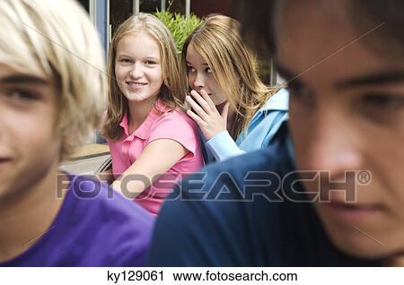 2 teenage girls whispering secrets, 2 teenage boys in foreground View Large Photo Image Stock Image - 2 teenage girls whispering secrets, 2 teenage boys in foreground. Fotosearch