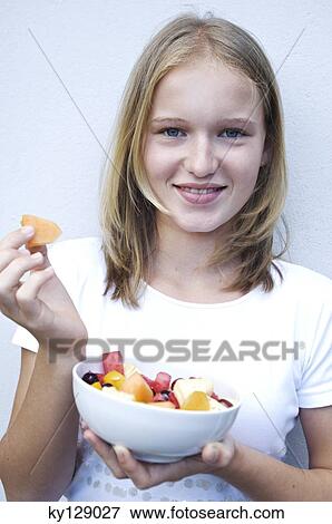 Portrait of a teenage girl eating fruit salad View Large Photo Image Stock Photo - Portrait of a teenage girl eating fruit salad. Fotosearch