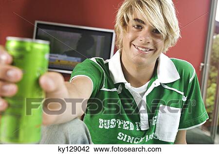 Smiling teenage boy holding can View Large Photo Image Stock Image - Smiling teenage boy holding can. Fotosearch