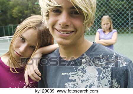 Smiling teenagers looking at the camera, teen girl with arms crossed in background, outdoors View Large Photo Image Stock Photo - Smiling teenagers looking at the camera, teen girl with arms crossed in background, outdoors. Fotosearch