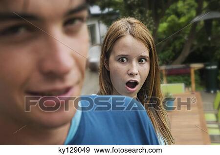 Surprised teenage girl with open mouth standing behind teenage boy View Large Photo Image Stock Photo - Surprised teenage girl with open mouth standing behind teenage boy. Fotosearch